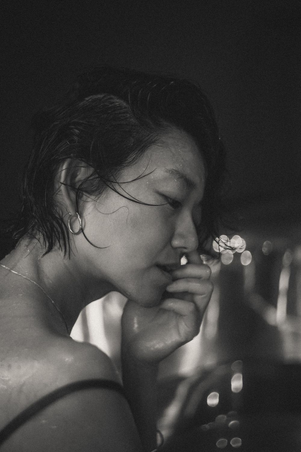 Artistic black and white portrait with bokeh lights in the background.