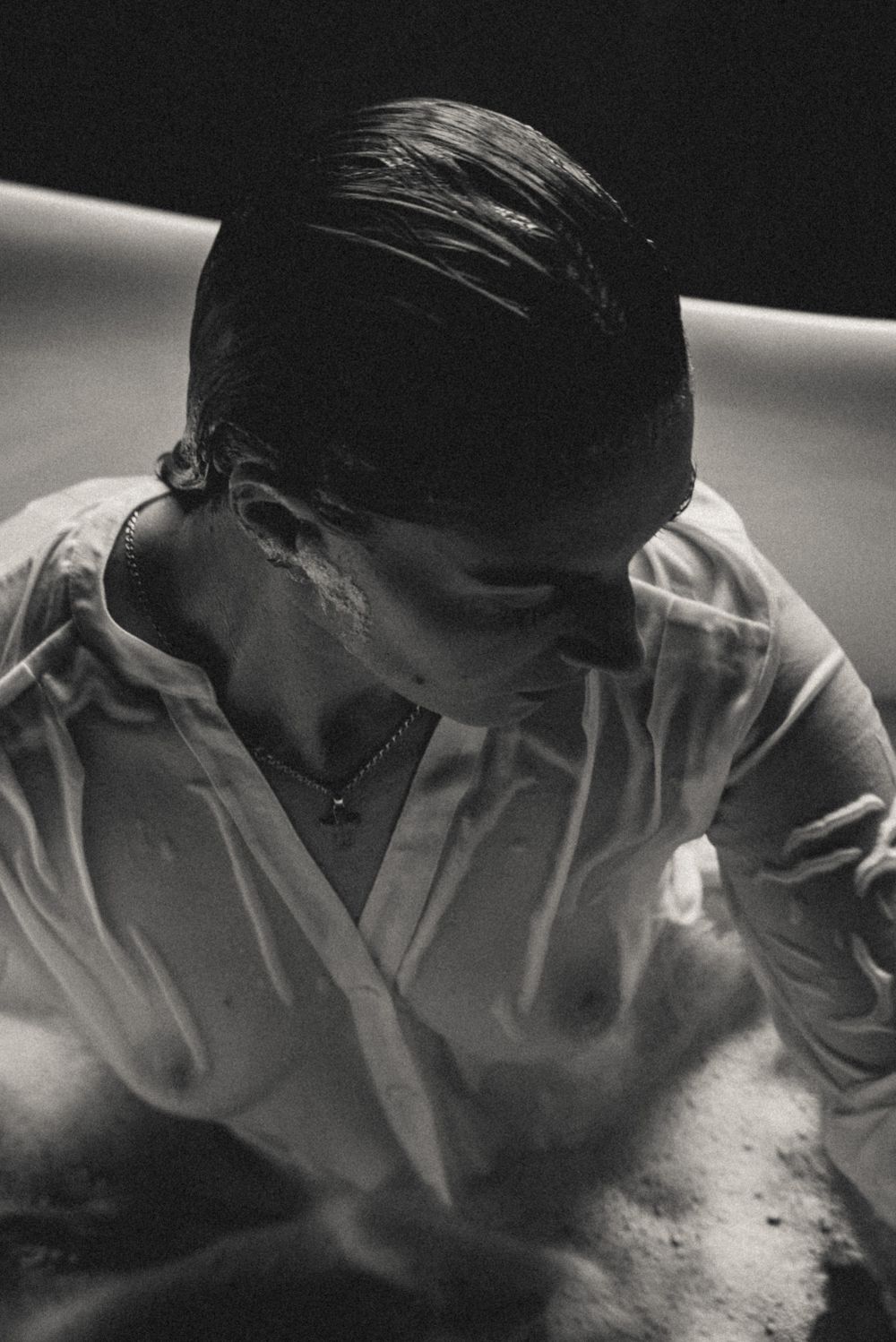 Black and white portrait showing wet hair and white button-down shirt.