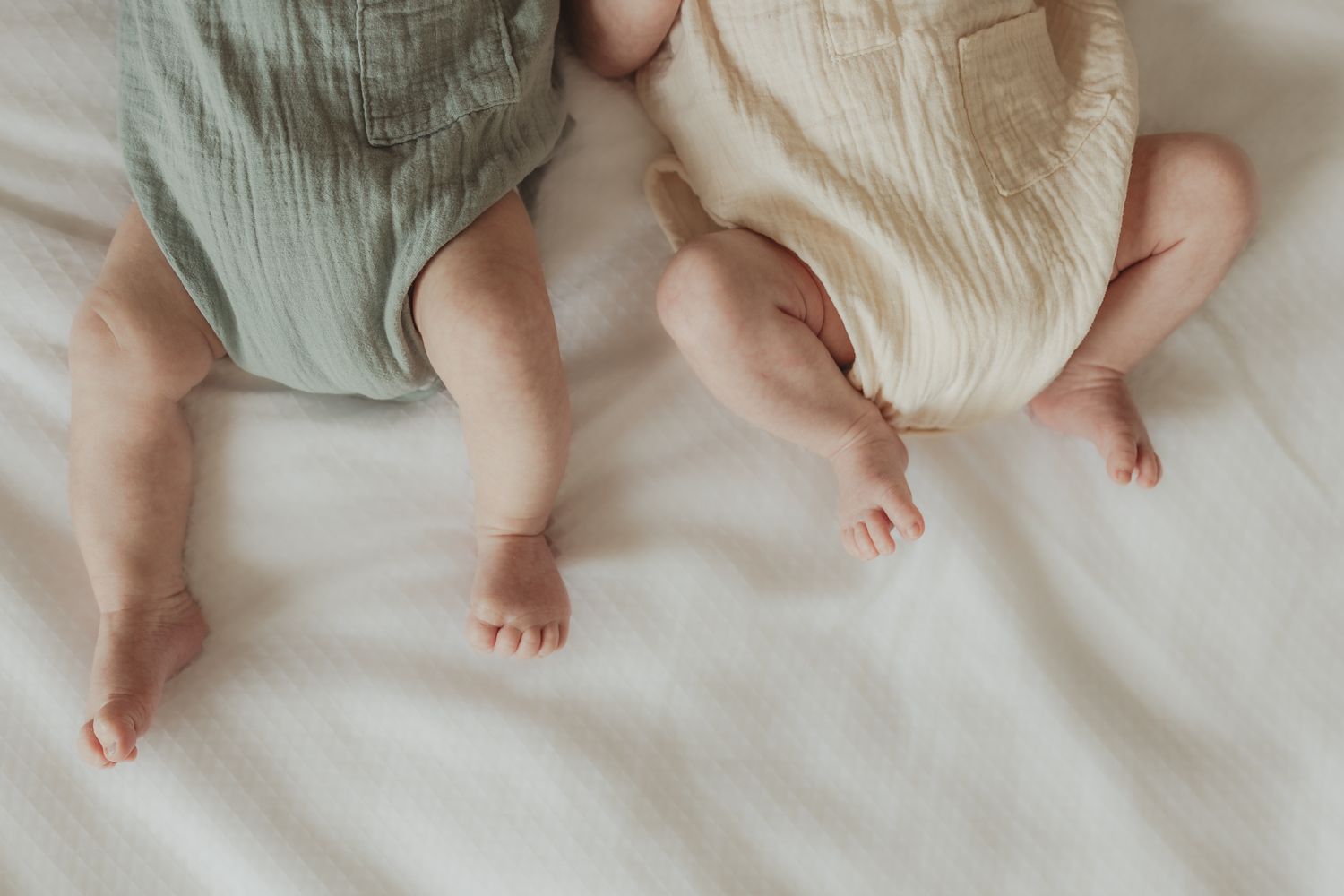 A series of close-up photos showing tiny baby feet against soft white bedding.