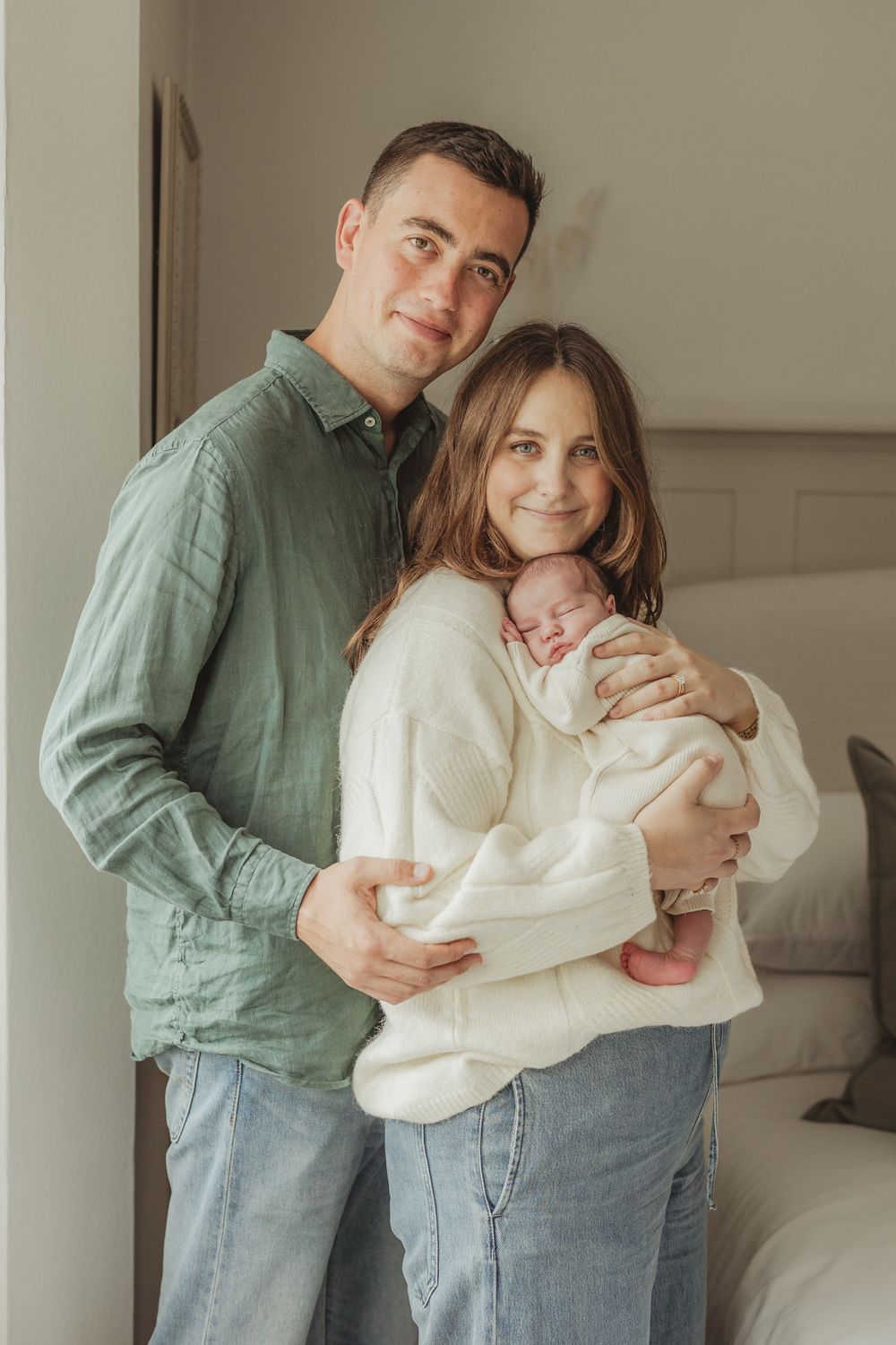 A couple in casual attire shares intimate embraces in a series of tender moments against a neutral wall background.
