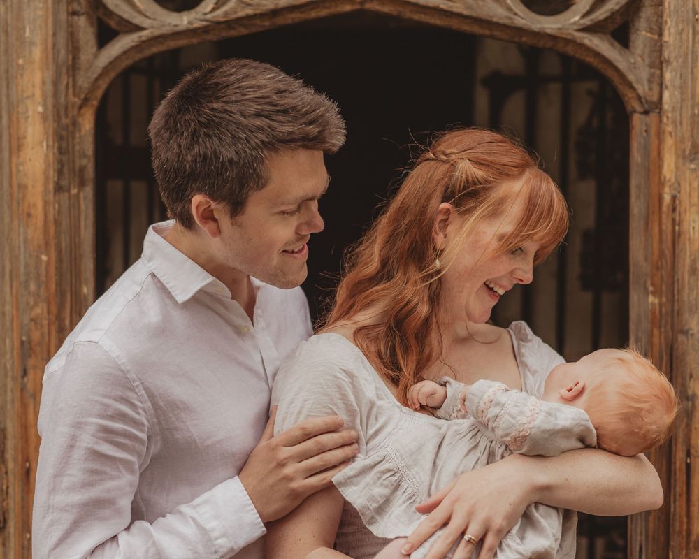 mum, dad and baby together outside a church in Wimbledon