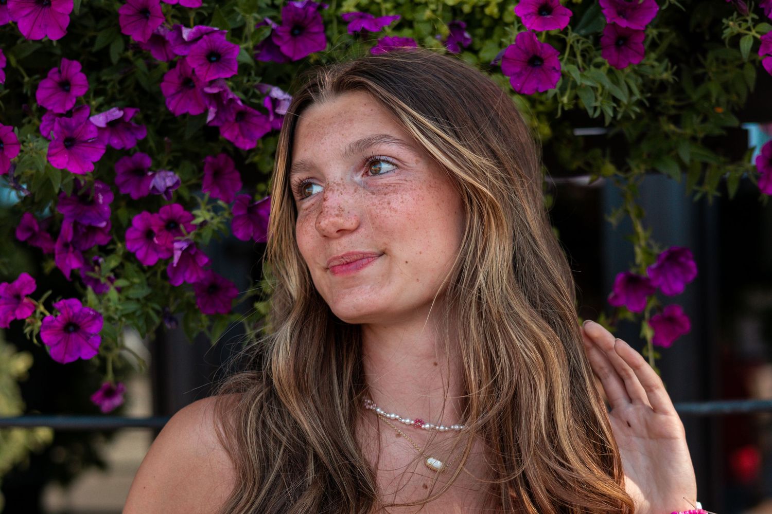 Portrait series with vibrant purple flowers in the background during golden hour lighting.
