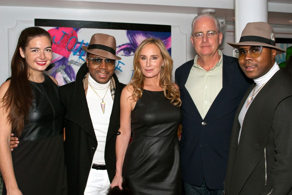 Group of people posing at indoor event wearing formal attire and hats.