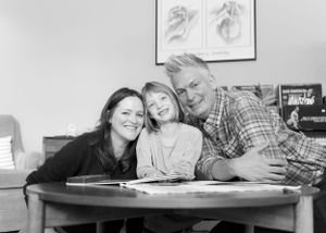 Black and white portrait of a family together in their home.