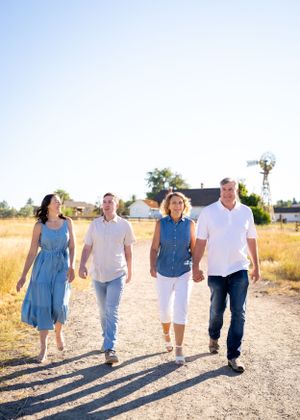 Family walking together on an outdoor dirt path at sunrise with long shadows.