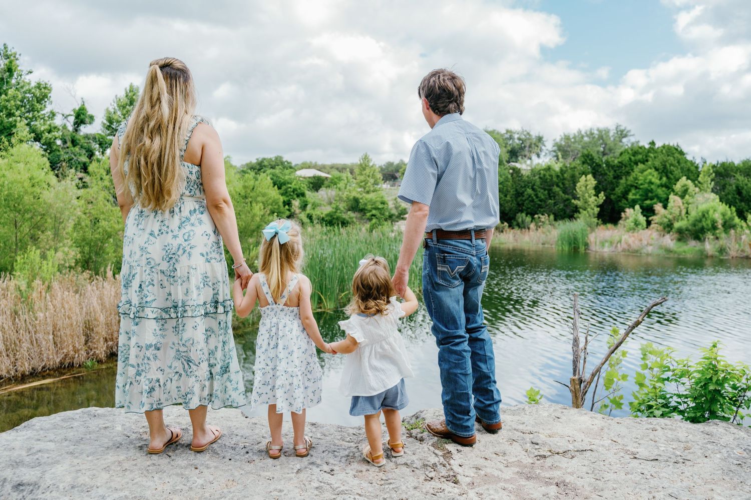 Family walking together in open field during golden hour.