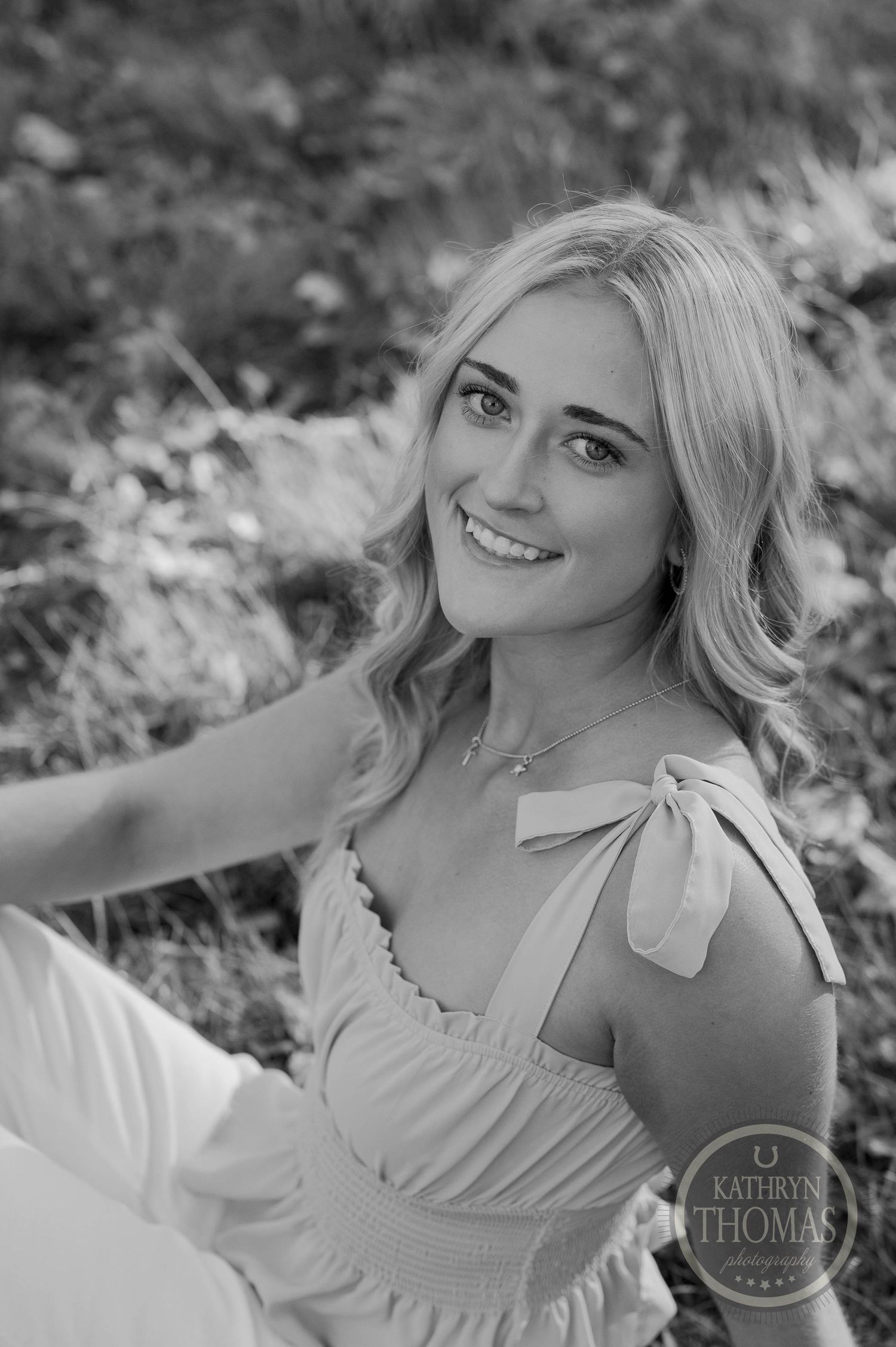 A black and white portrait featuring a summery outfit with bow detail.