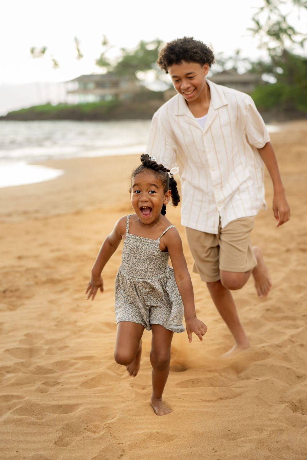 Playful running and jumping moments captured on a Hawaiian beach.
