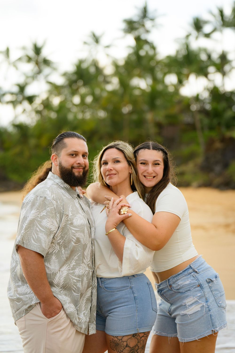 Group photo session on the beach with coordinated casual outfits.