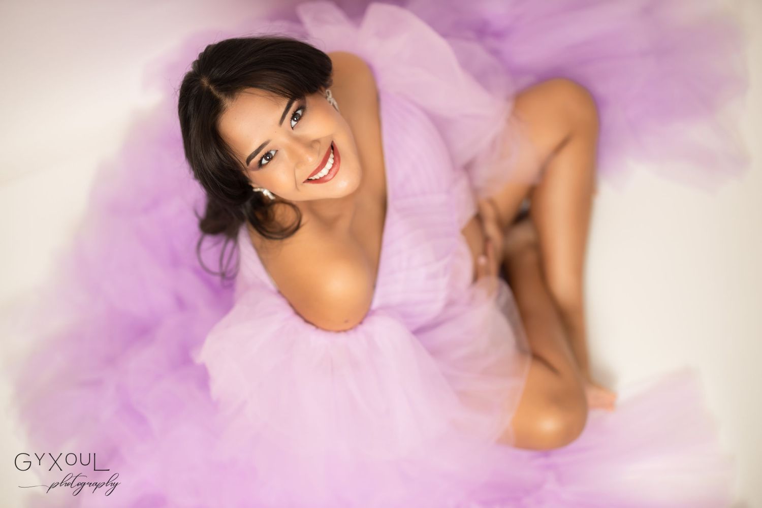 Dreamy maternity photo with subject in flowing lavender tulle dress.