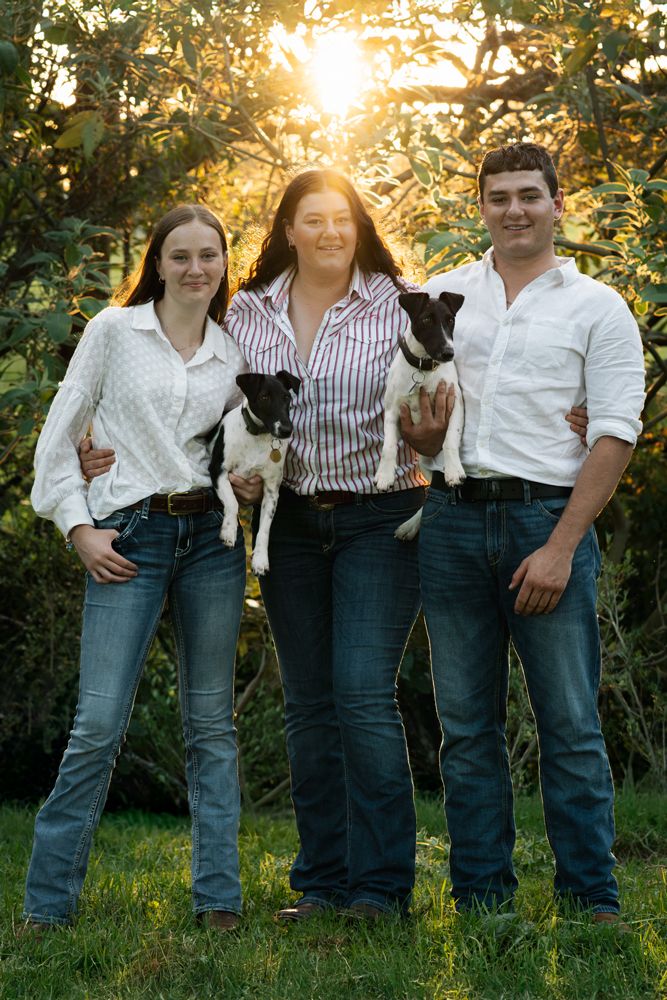 Siblings with their dogs at a dog-friendly family photoshoot in NSW, captured in a golden-hour moment by a Central Coast family photographer