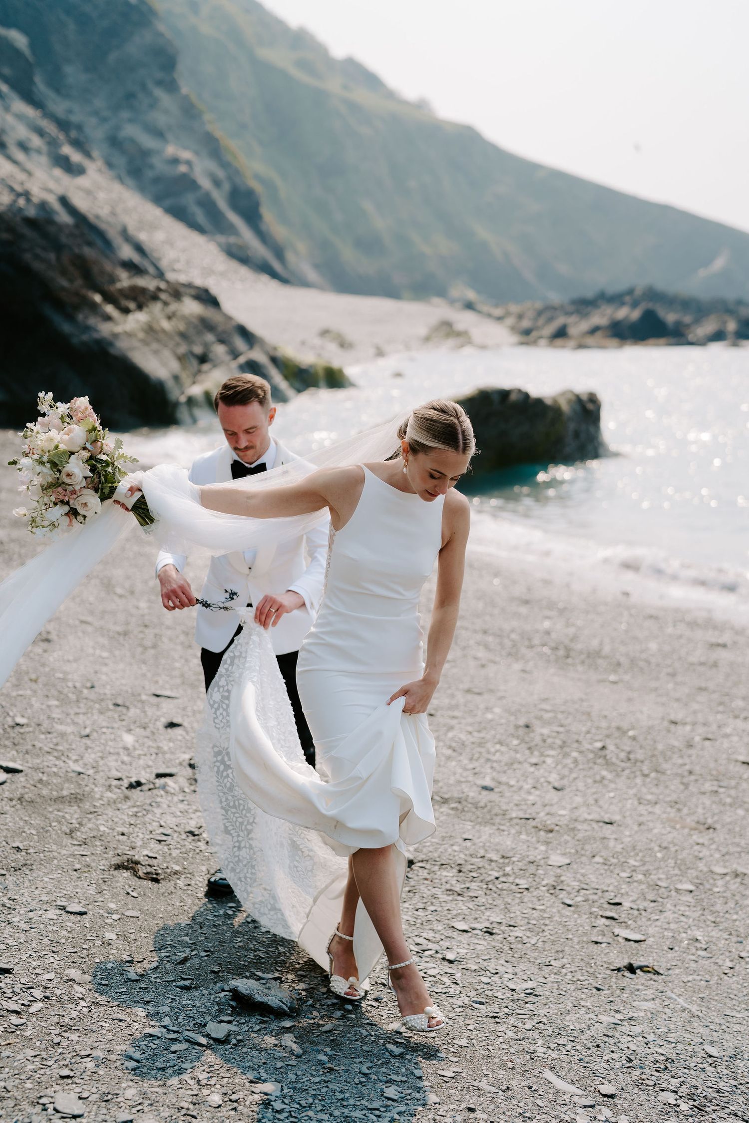 Bride and Groom walking along beach at Tunnels beach wedding venue in north devon