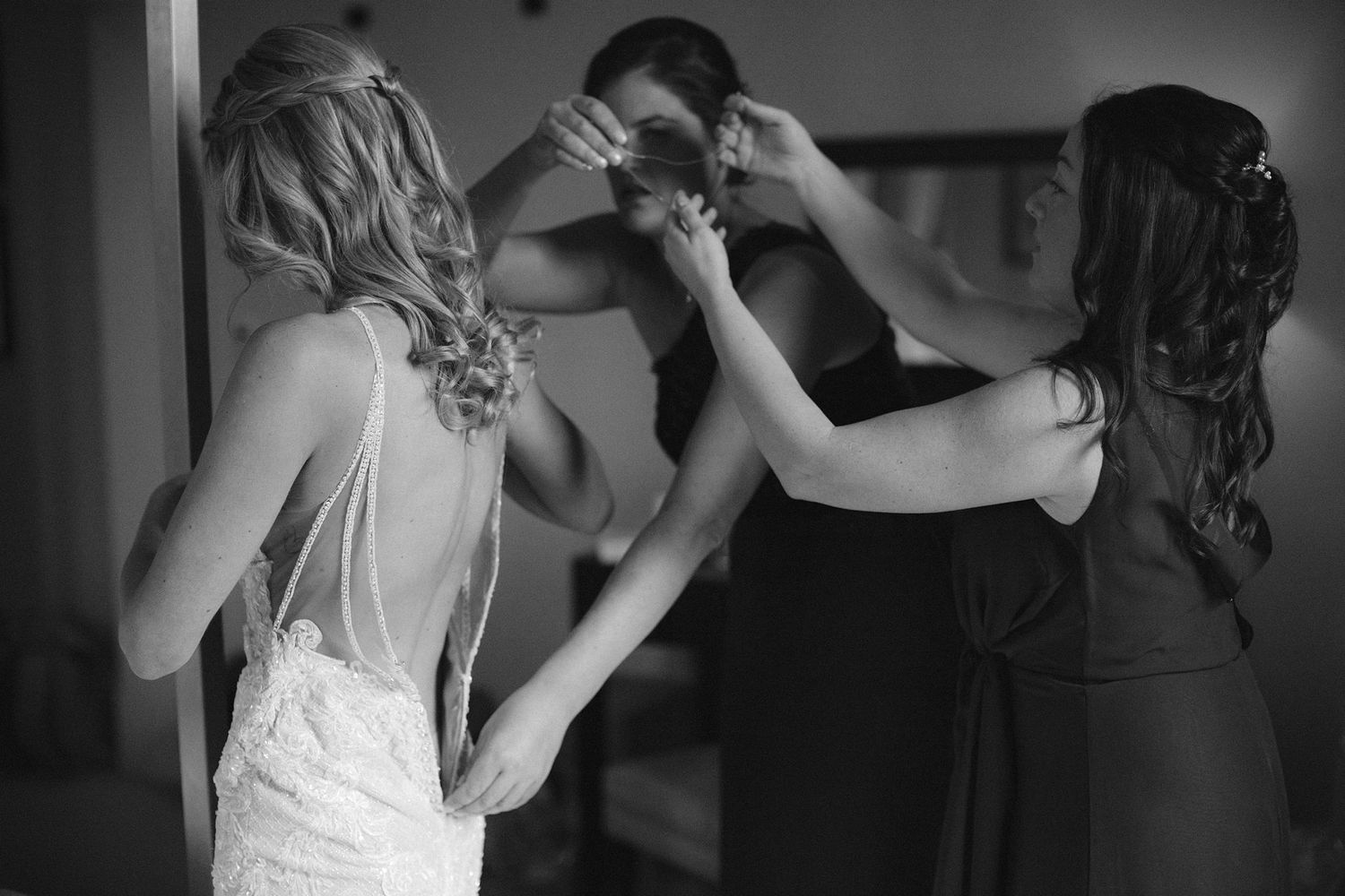 Black and white photograph at Halifax Tower hotel showing final preparations with a bridal gown being adjusted in an intimate moment.