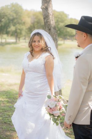 Romantic outdoor wedding photos featuring a bride in white dress and groom in light colored suit.