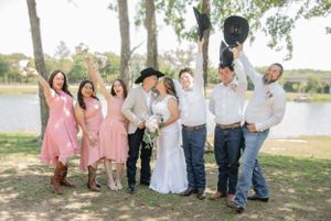 Wedding party in pink dresses and casual attire relaxing outdoors.