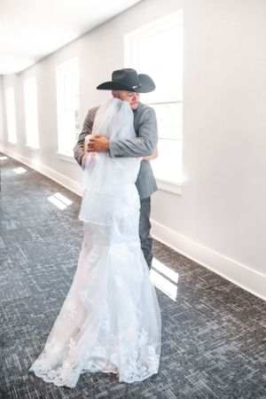 First look wedding photos in bright indoor setting with lace dress details.