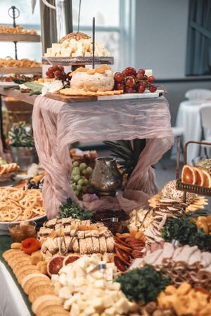 Elaborate wedding reception buffet spread with cheese, fruits, and appetizers.