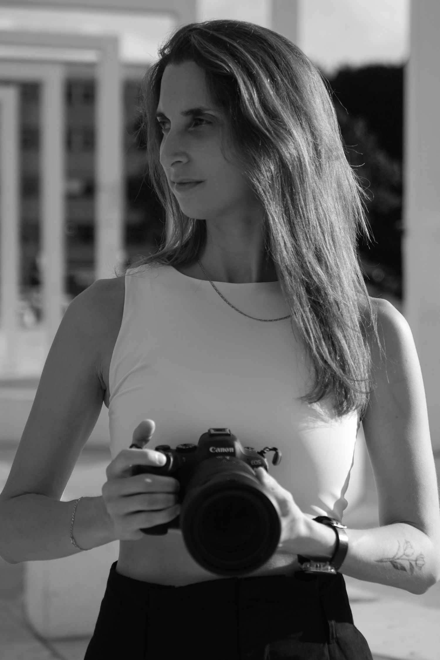 Portrait of the photographer Nicole Feinholz, holding a camera,  looking super sharp and focused
