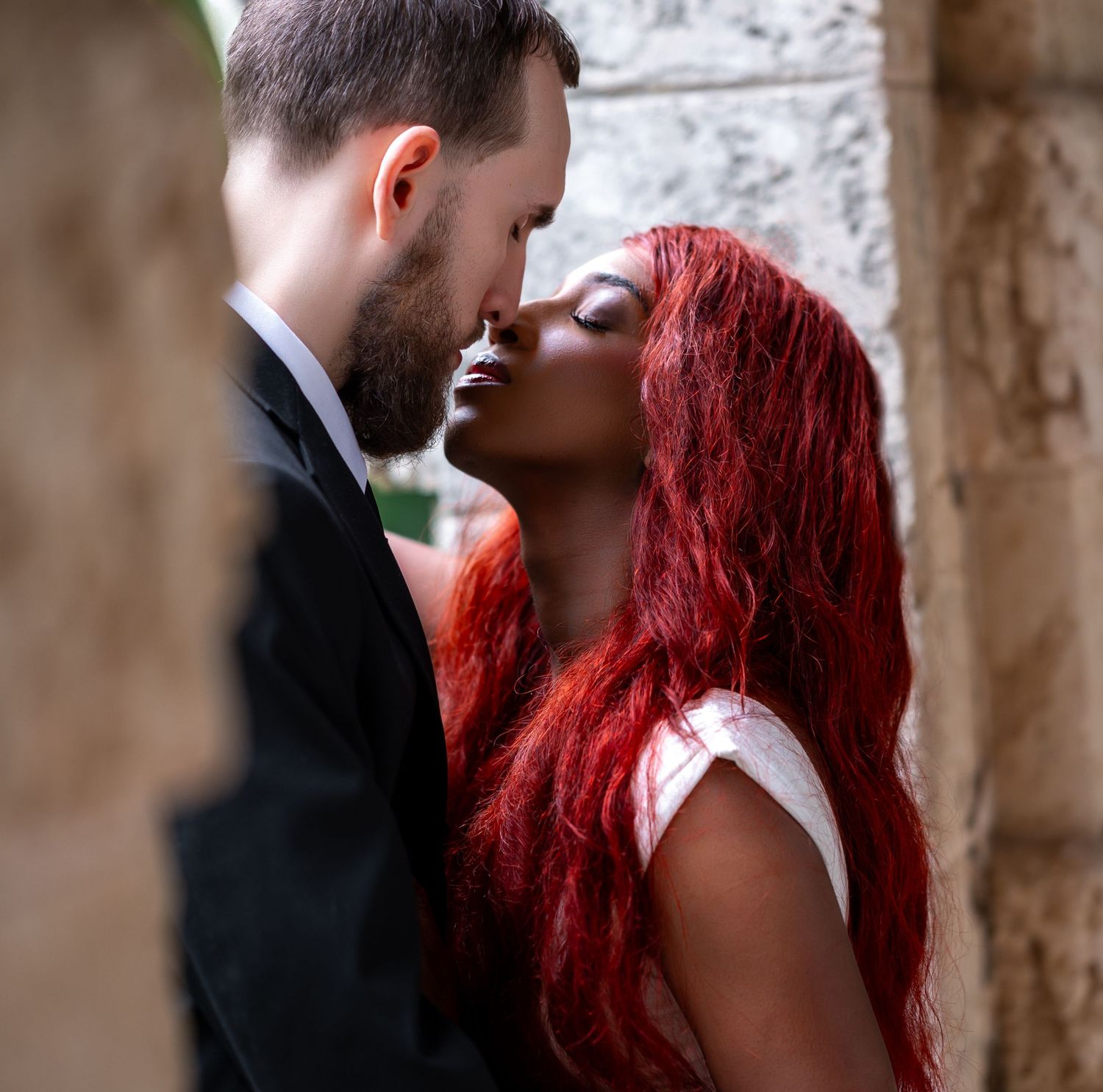 Soft natural light touches the bride and groom just before their lips meet during their Palm Beach estate wedding.