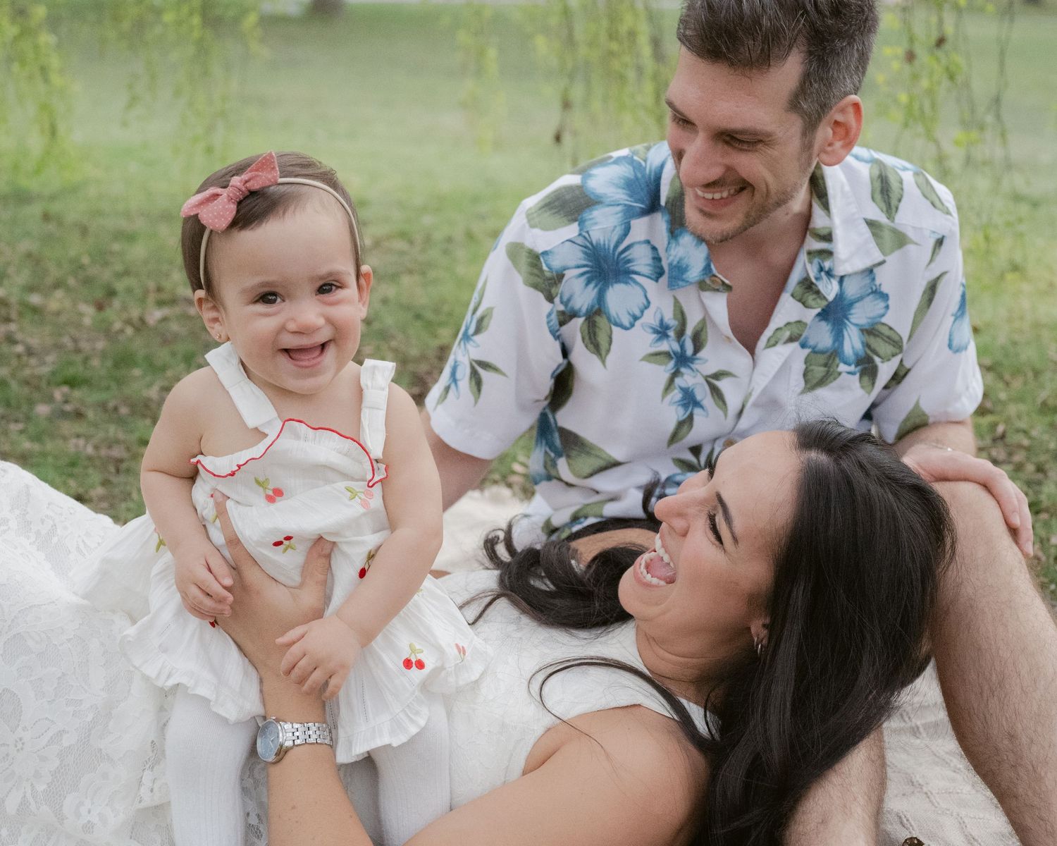 Family laughing on a blanket at Jericho Beach during a session with a Vancouver family photographer.