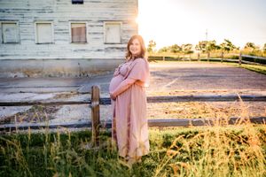 Flowing maternity gown on a pregnant woman, captured during a sunset maternity session.