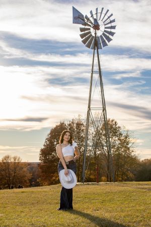 Portrait session with vintage windmill during scenic golden hour.