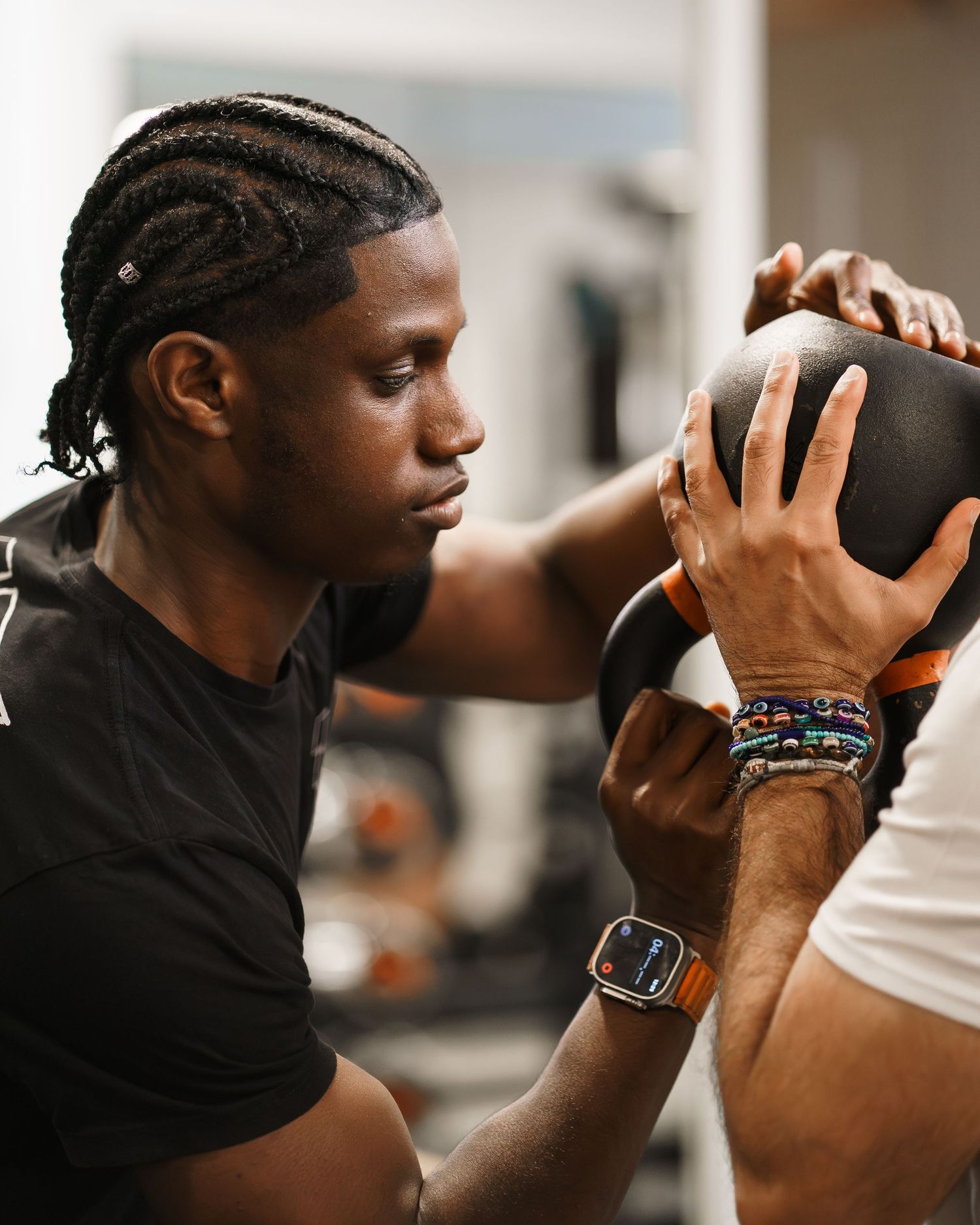 Two athletes in a gym grip a medicine ball together during an intense workout session.