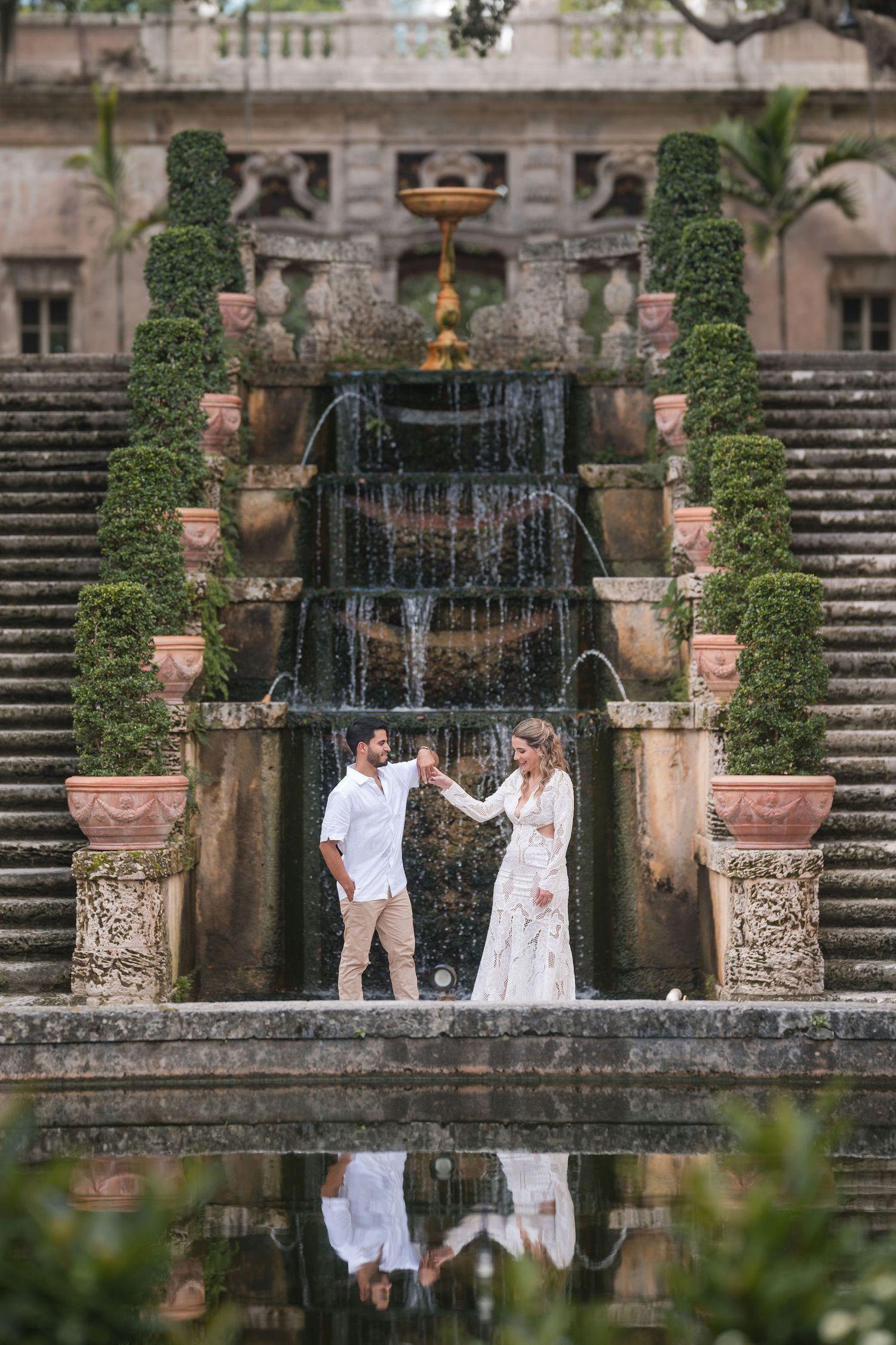 Bride and groom share a quiet moment before Vizcaya’s historic fountain, surrounded by elegant stone architecture and greenery.