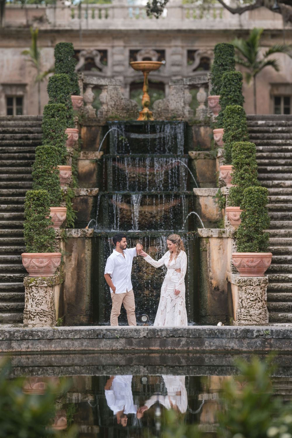 Bride and groom share a quiet moment before Vizcaya’s historic fountain, surrounded by elegant stone architecture and greenery.