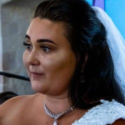Emotional bride in white veil and diamond necklace with tears on her wedding day.