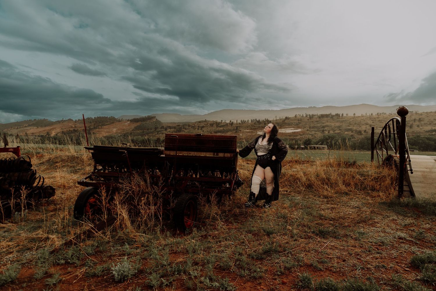Woman stands and poses in field for dramatic, cinematic, portrait, and modeling photos in Fort Collins, Colorado