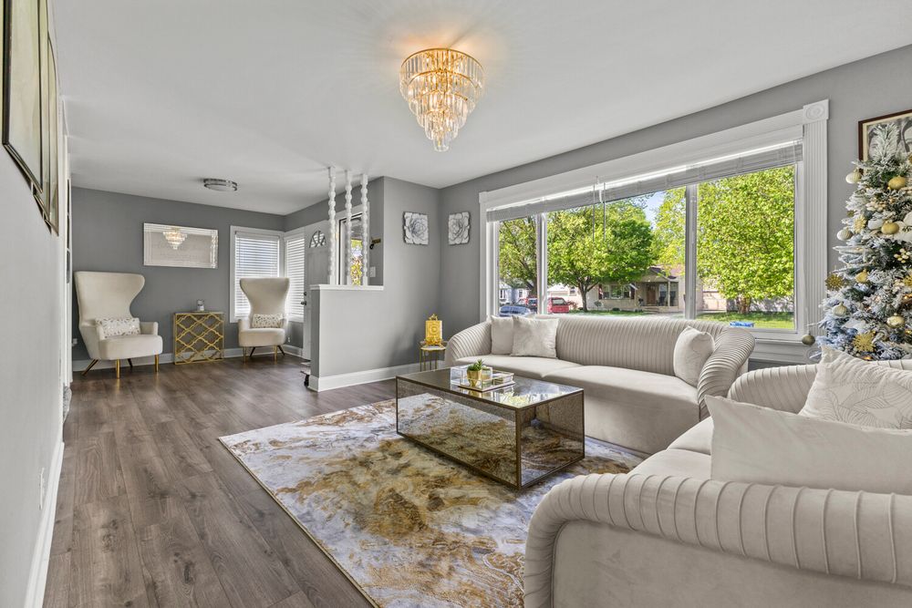 Living room with gold chandelier and large picture window in Dearborn Michigan home