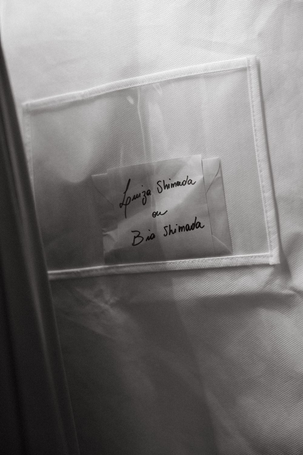 Close-up of handwritten note on wedding dress garment bag.