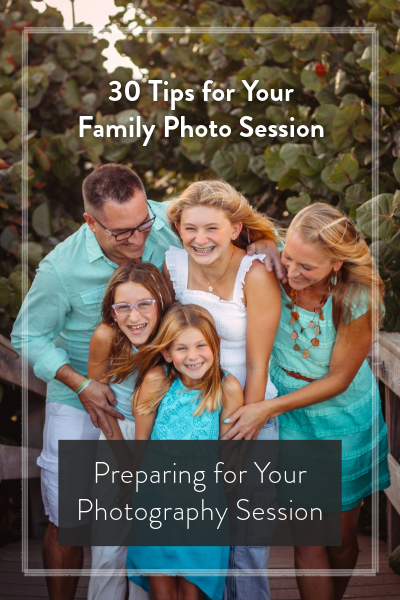 A happy family of five poses outdoors in coordinating teal outfits for a professional family photo session.