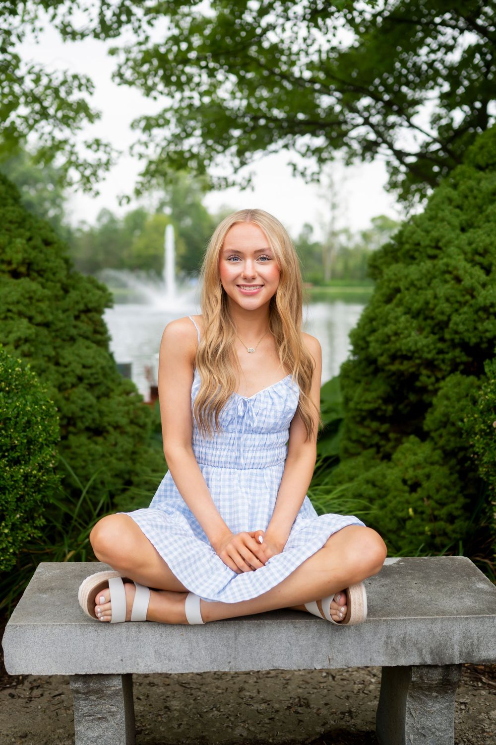 Summer portrait session on a concrete wall overlooking water.