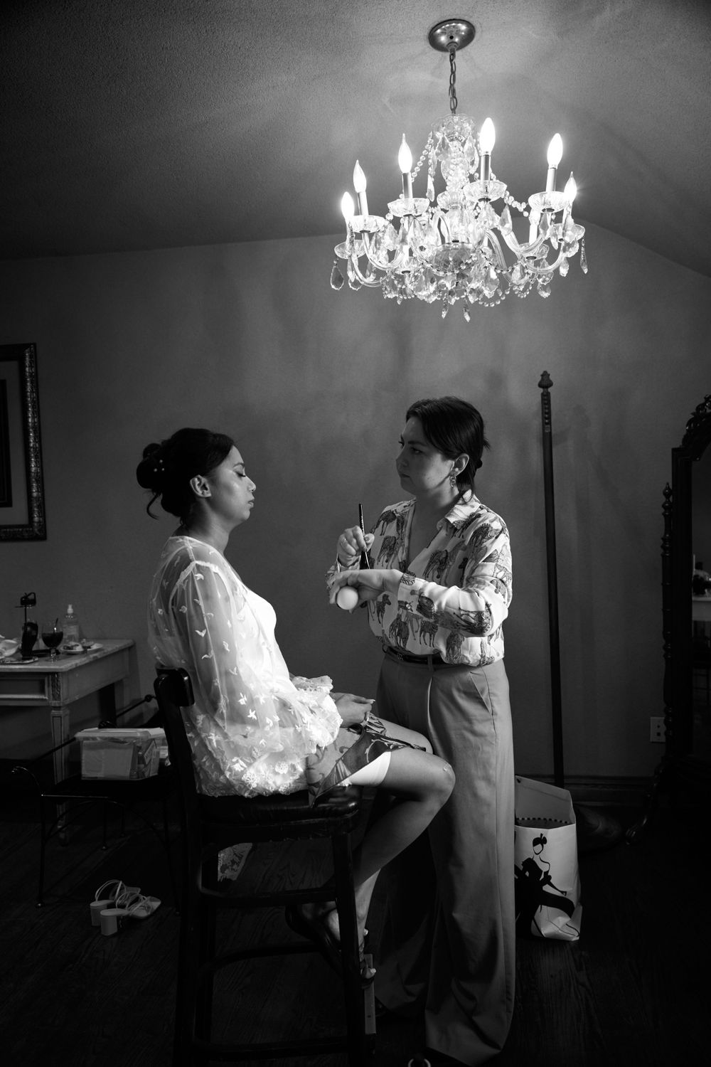 Wedding preparation scene with crystal chandelier and elegant furniture.
