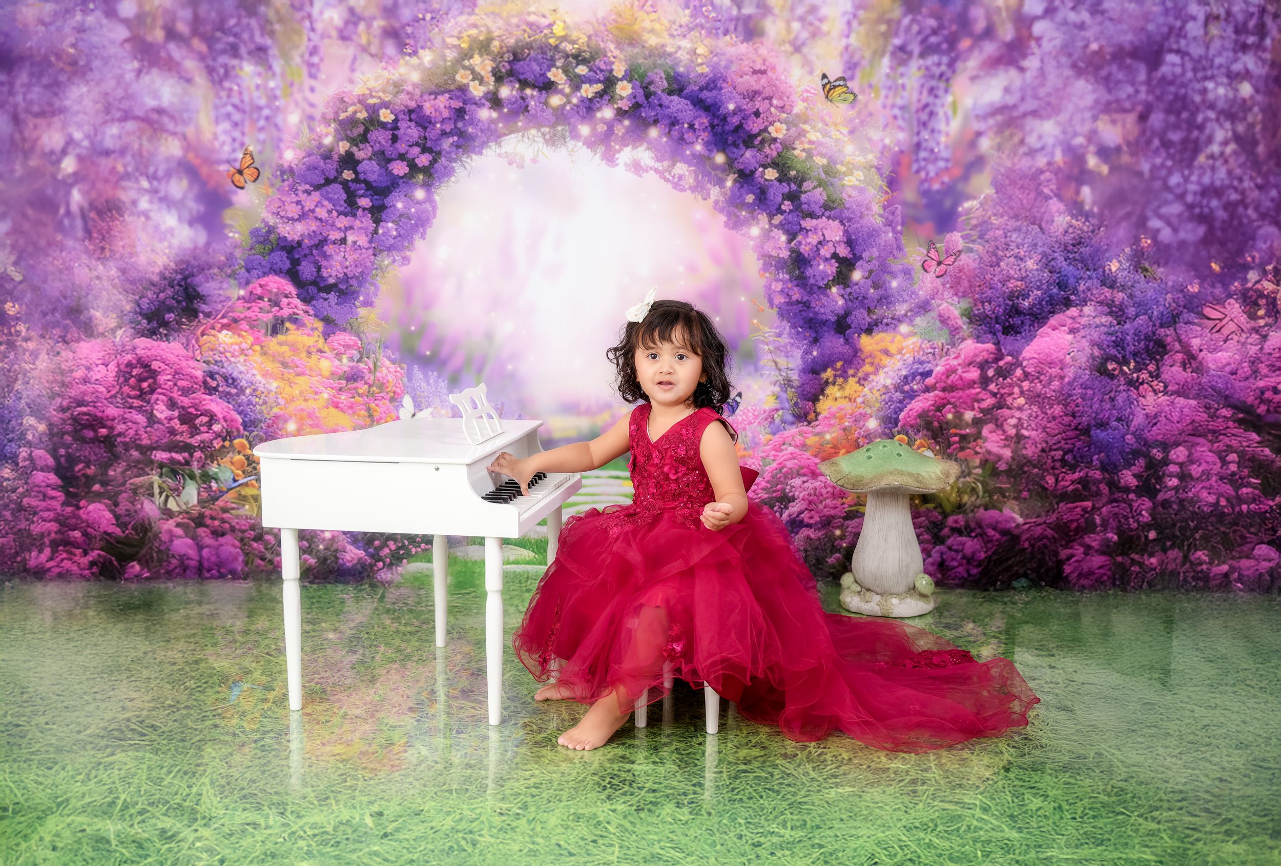 Enchanted garden photoshoot with white piano and flowing red tulle dress.