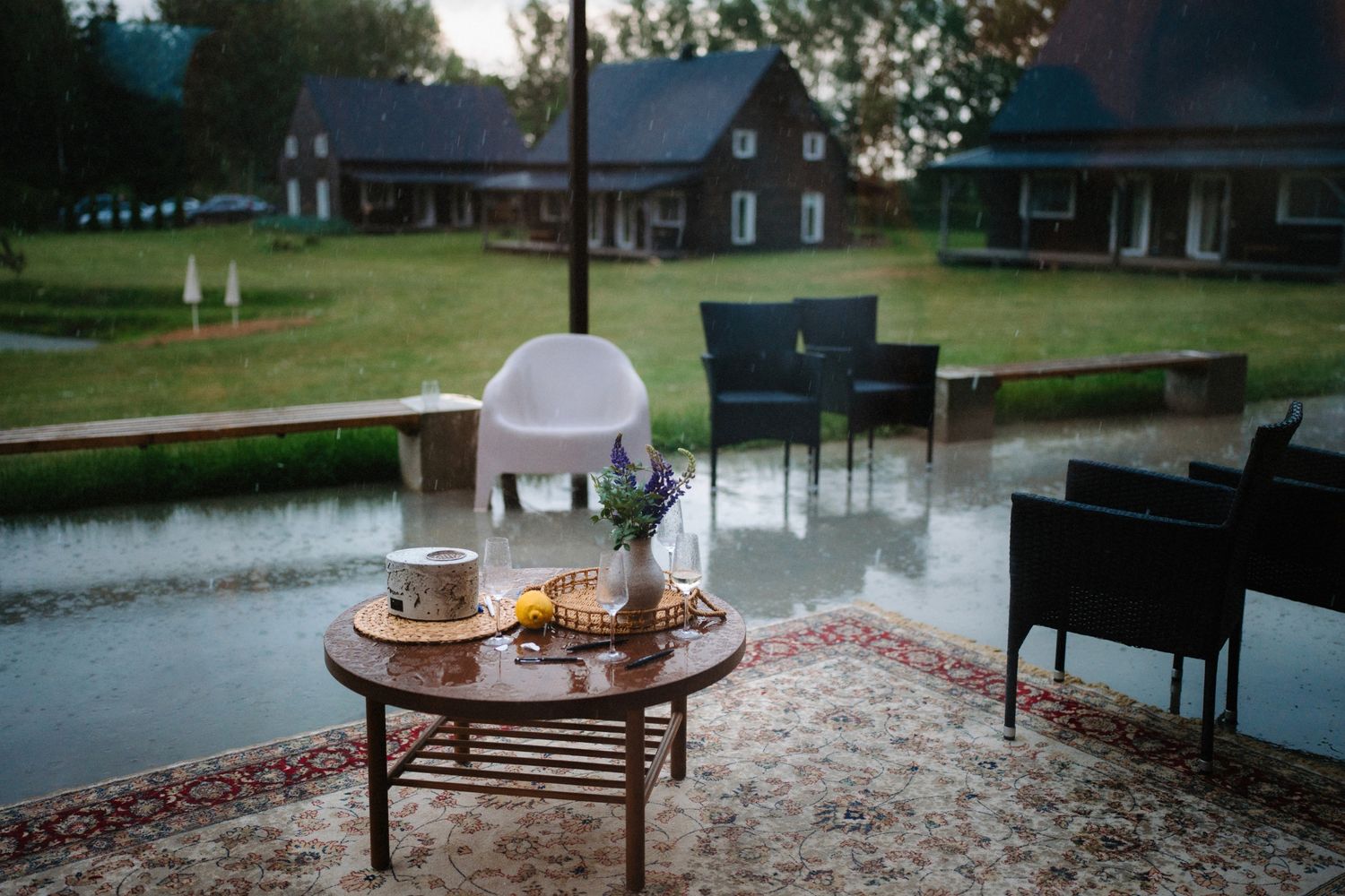 Rustic lakeside venue with wooden furniture and decorative setup for an outdoor event.