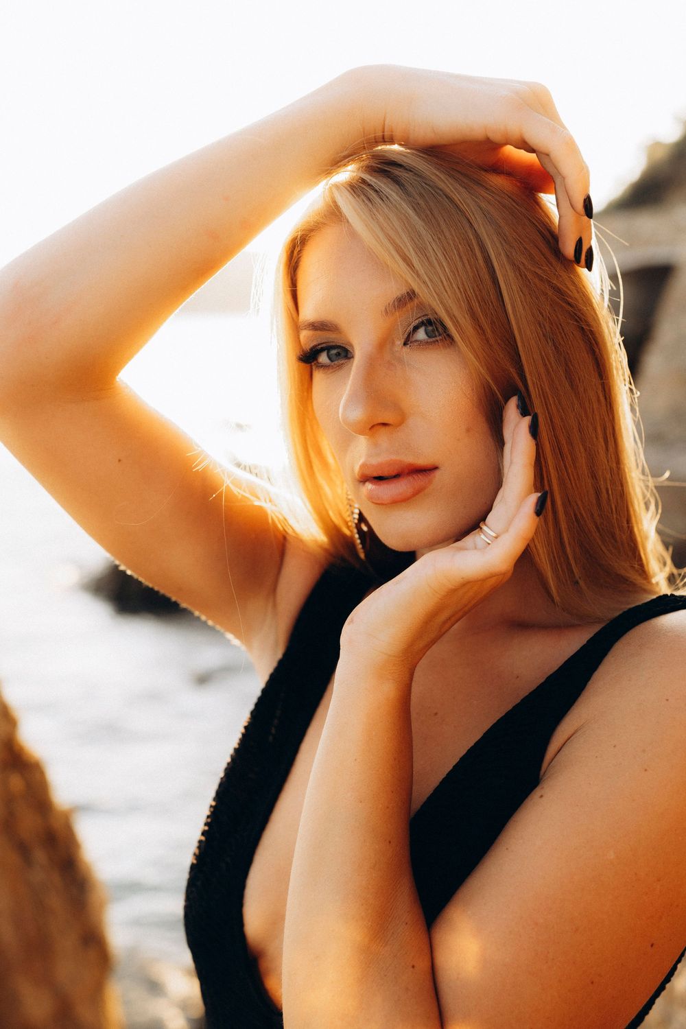 A series of artistic portraits showing a person with red hair in a black top against a warm sunset glow.