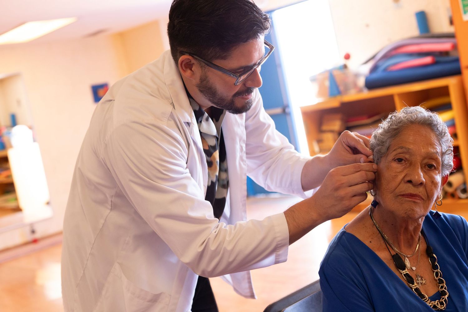 Healthcare workers administering vaccines to elderly patients in a medical setting.