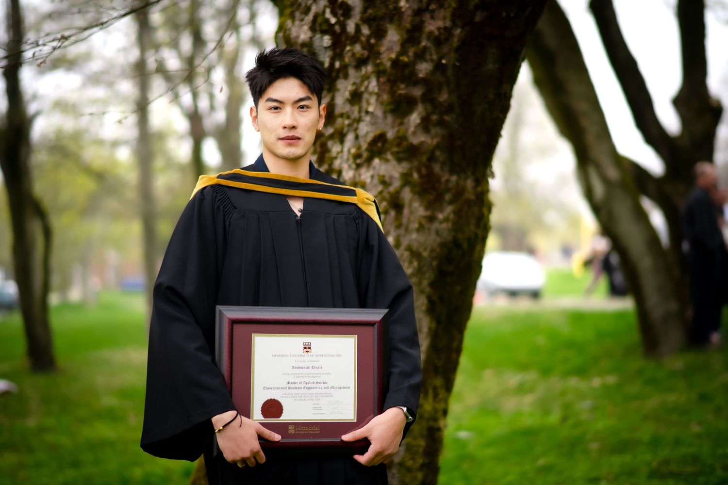Graduation photo of a man looking confidently at the camera, capturing a moment of pride and achievement.