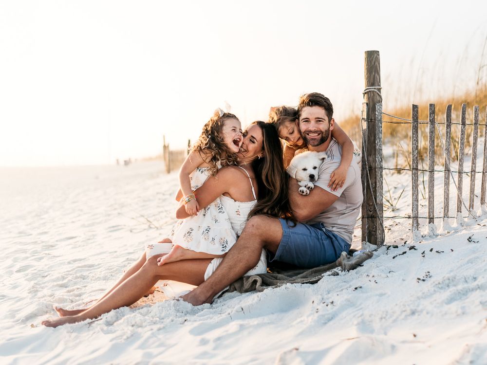 Romantic couple lounging together on white sand beach during sunset.