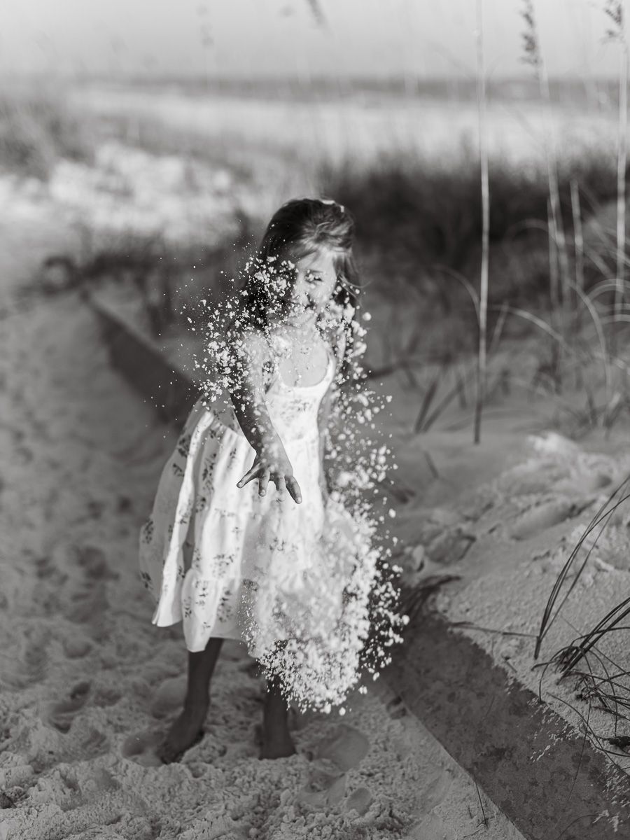 Black and white vintage photo showing water splashing effects on a sandy beach.