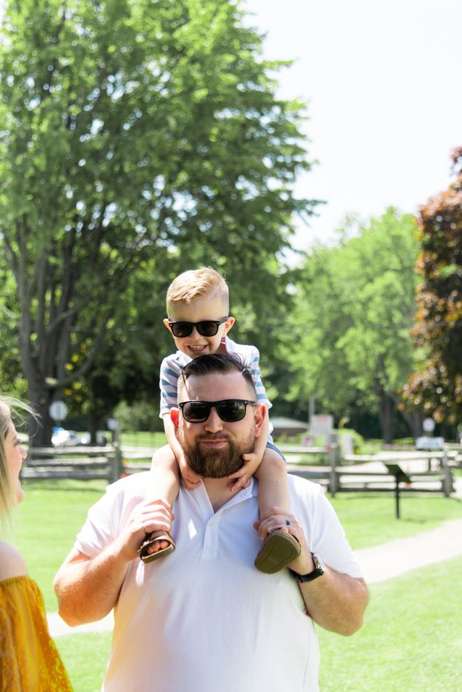 Father and child wearing sunglasses enjoy sunny day at park.