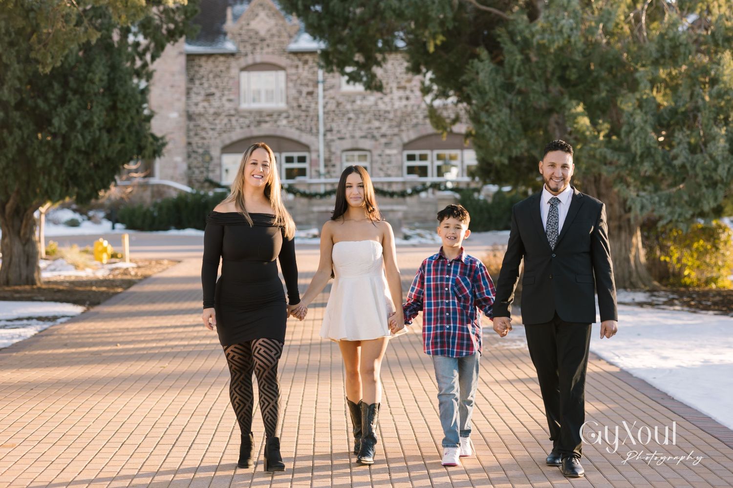 Family walking together in coordinated outfits on stone path during winter.