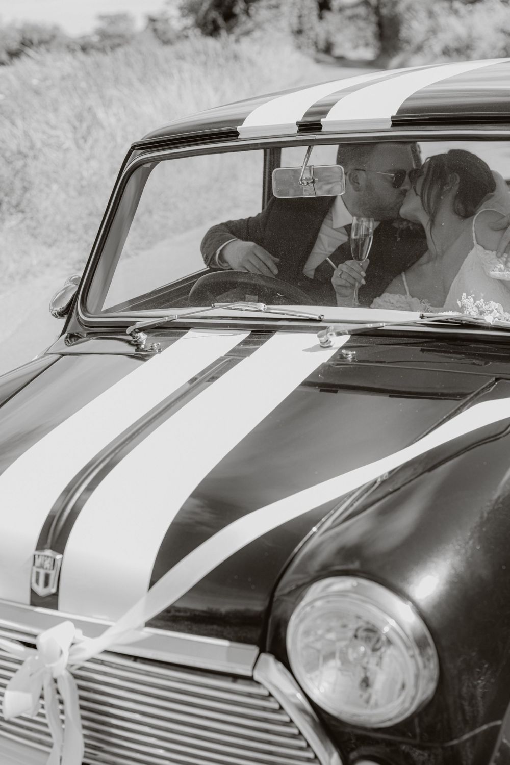 Close-up details of a vintage Mini Cooper with distinctive racing stripes.