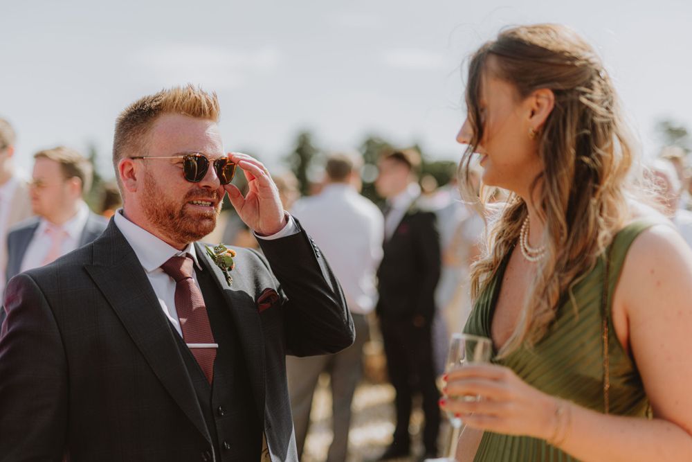 Wedding guests mingling and celebrating at an outdoor summer reception.