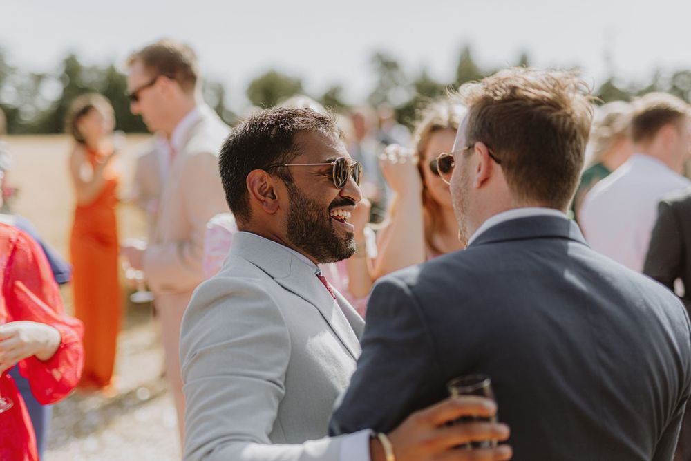 Wedding guests socializing during an outdoor summer celebration.