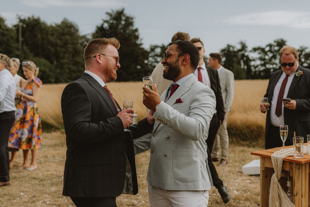 Guests in formal attire celebrating at an outdoor wedding reception.