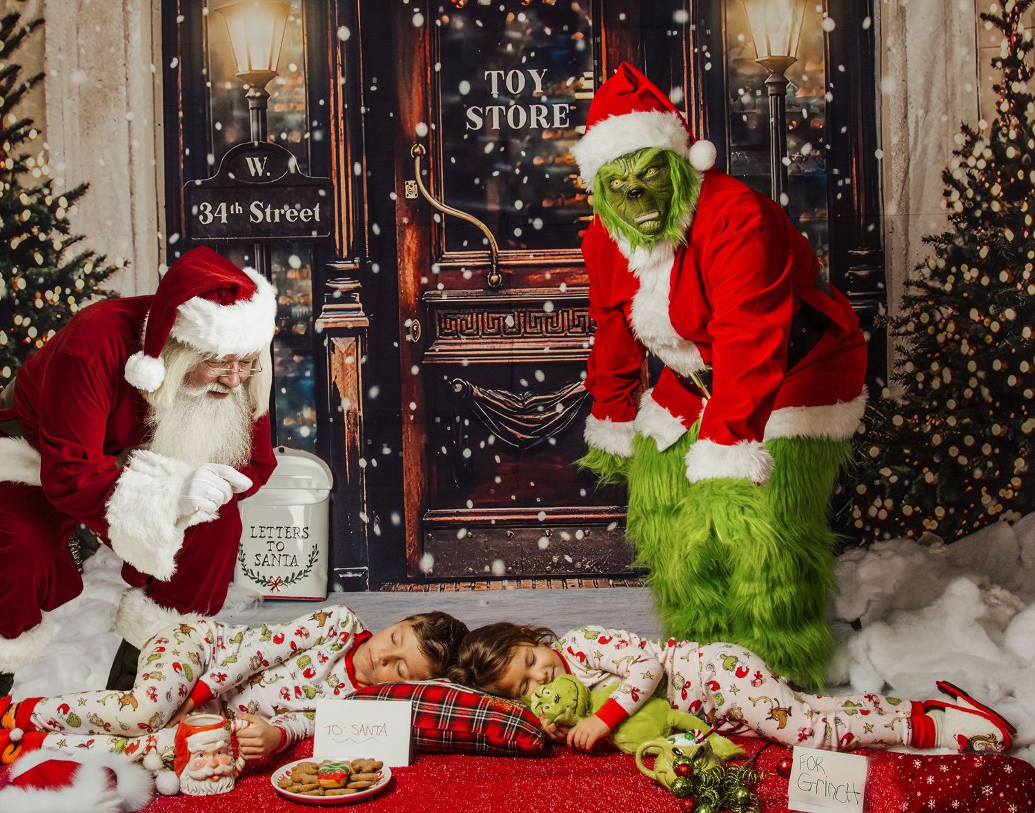 Santa Claus and the Grinch pose next to a store entrance decorated for Christmas with presents and festive decor.
